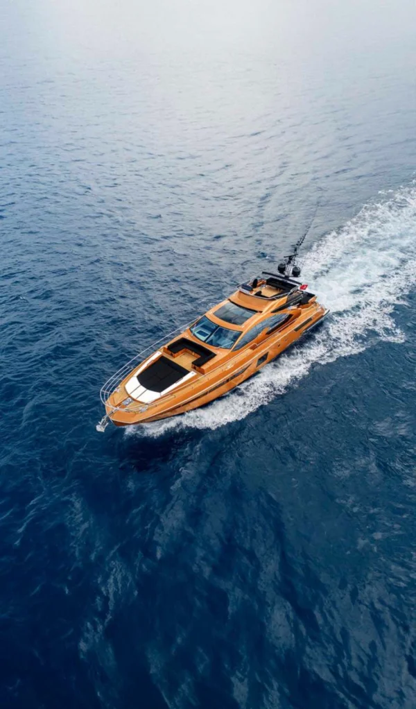 A luxurious motor yacht gliding through the clear waters, showcasing the elegance of yacht rental in Dubai